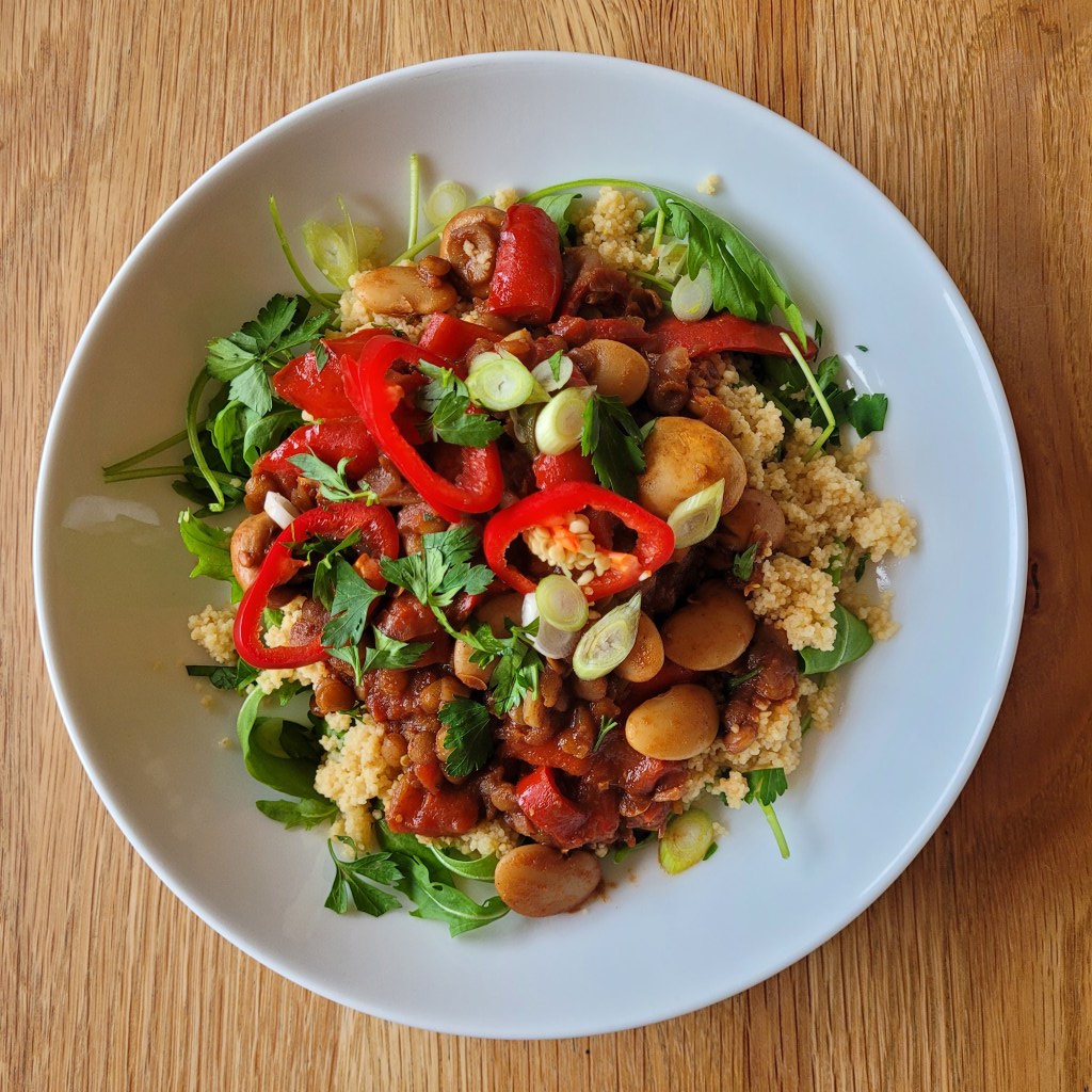 Lentil & Mushroom Bean Medley, drizzled with pomegranate molasses and served on a bed of fresh rocket and fluffy couscous.