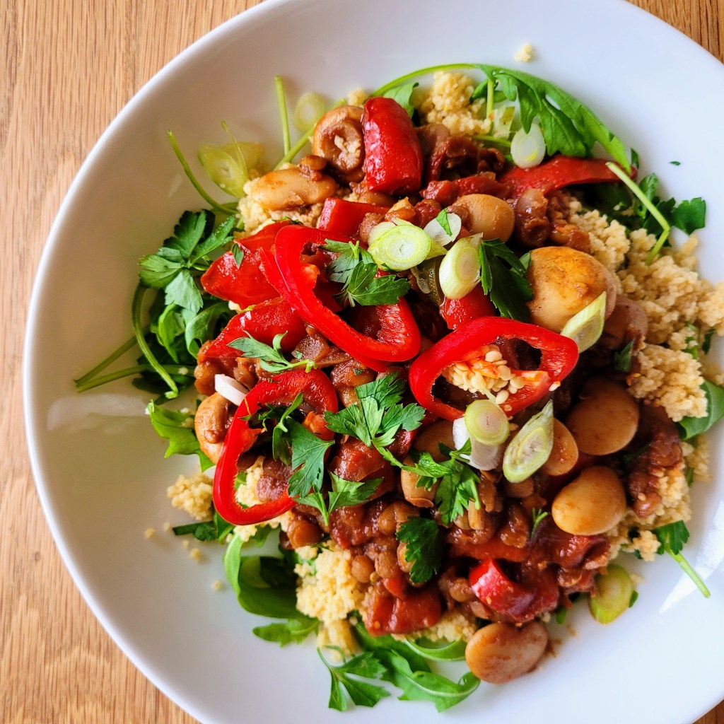 Lentil & Mushroom Bean Medley, drizzled with pomegranate molasses and served on a bed of fresh rocket and fluffy couscous.