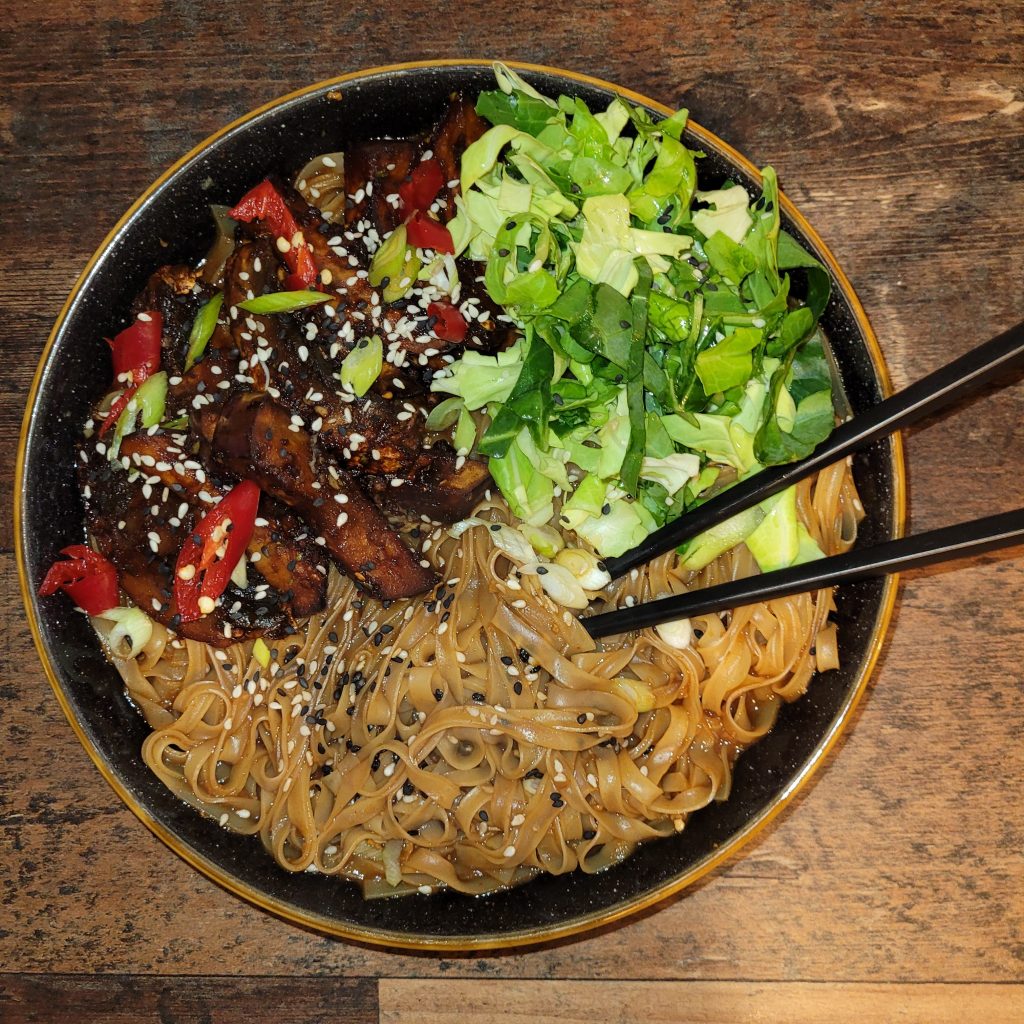 A bowl with aubergine and noodles