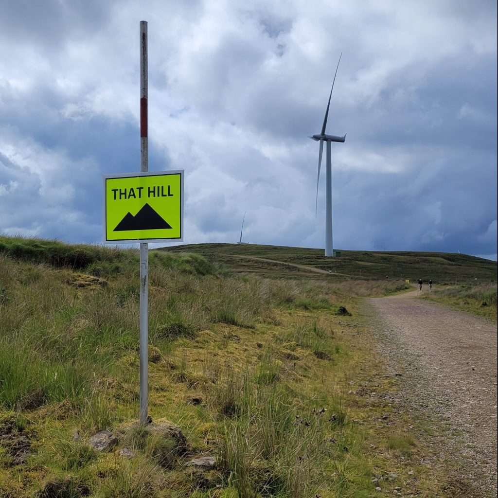 a sign with "that hill" text reminding runners they are about to ascend a hill in an ultramarathon